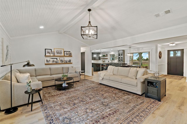 living room with crown molding, vaulted ceiling with beams, a notable chandelier, and light hardwood / wood-style floors