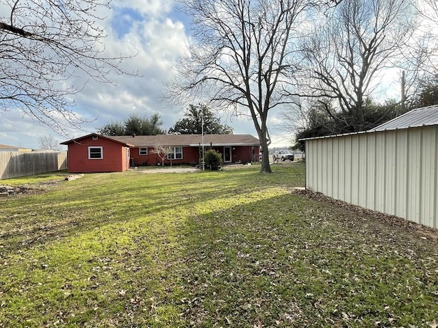 view of yard with an outbuilding and fence