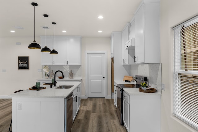 kitchen with pendant lighting, sink, appliances with stainless steel finishes, white cabinetry, and a center island with sink