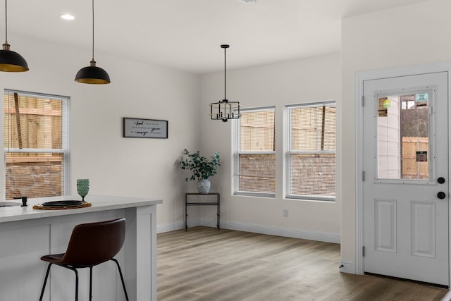 dining space with hardwood / wood-style floors and a chandelier