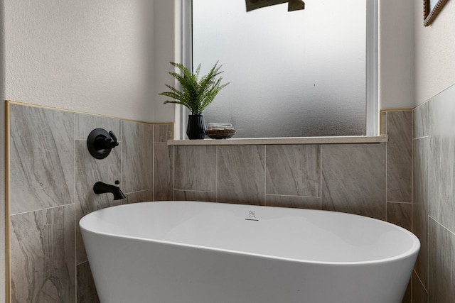 bathroom with tile walls and a tub to relax in