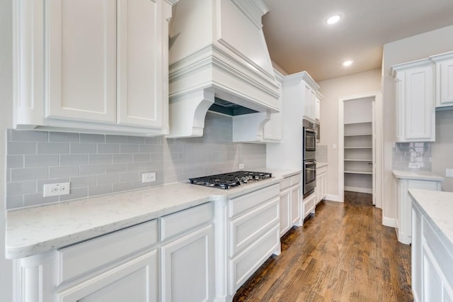 kitchen with white cabinetry, stainless steel gas stovetop, light stone counters, and custom exhaust hood