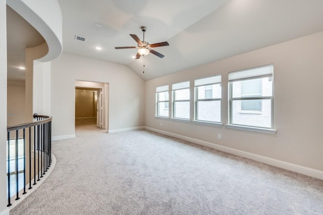 spare room featuring lofted ceiling, light carpet, and ceiling fan