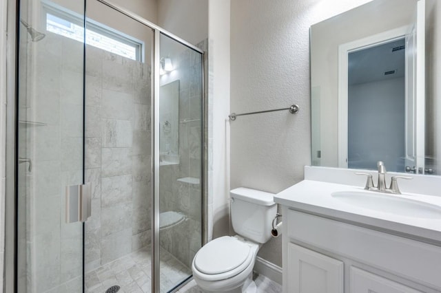 bathroom featuring vanity, toilet, and a shower with shower door