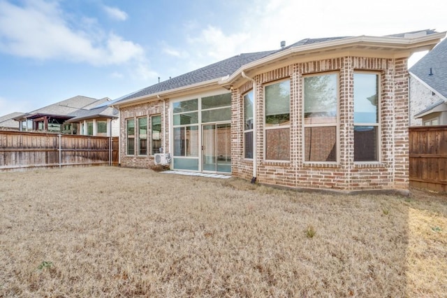 rear view of property with a lawn