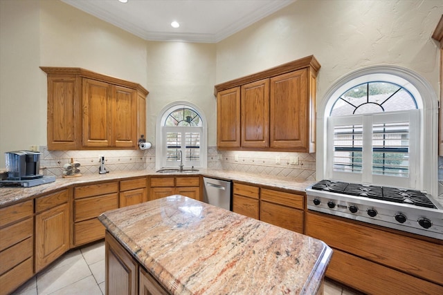 kitchen with sink, a center island, ornamental molding, appliances with stainless steel finishes, and decorative backsplash