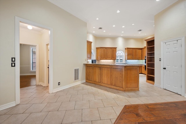 kitchen featuring crown molding, a kitchen breakfast bar, tasteful backsplash, light tile patterned flooring, and kitchen peninsula