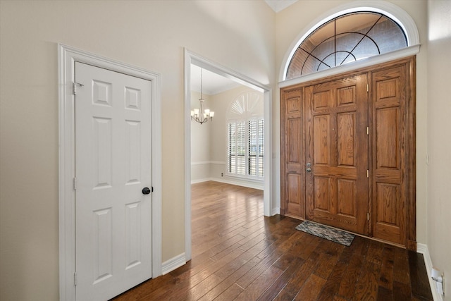 foyer entrance with dark hardwood / wood-style flooring and an inviting chandelier