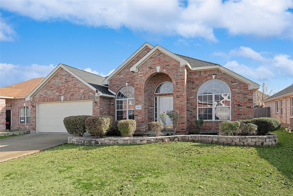 front facade featuring a garage and a front yard