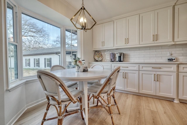 dining area with light hardwood / wood-style flooring and a chandelier