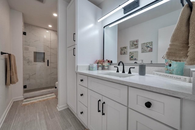 bathroom featuring vanity, toilet, and walk in shower