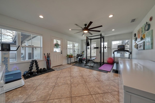 exercise area featuring light tile patterned floors and ceiling fan