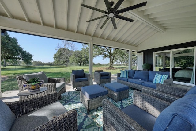 sunroom featuring lofted ceiling with beams and ceiling fan