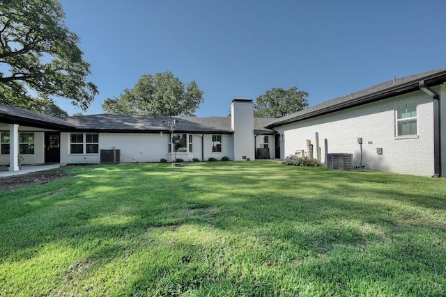 back of property featuring a yard and central AC unit