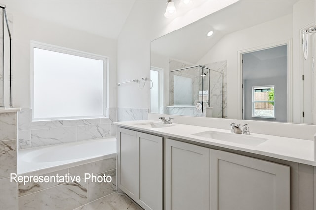 bathroom with lofted ceiling, vanity, and independent shower and bath