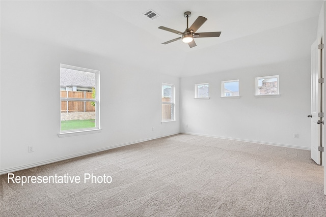 spare room with light carpet, a wealth of natural light, and ceiling fan