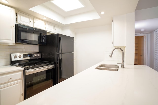 kitchen with white cabinetry, sink, decorative backsplash, and black appliances