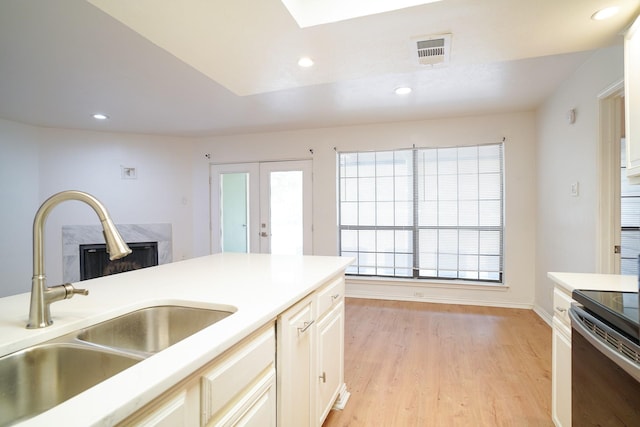 kitchen with range with electric stovetop, sink, light hardwood / wood-style floors, and french doors