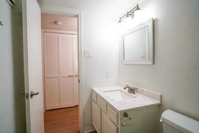 bathroom featuring vanity, toilet, and hardwood / wood-style floors