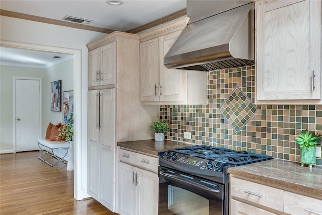 kitchen featuring extractor fan, light wood-type flooring, ornamental molding, black range with gas stovetop, and decorative backsplash