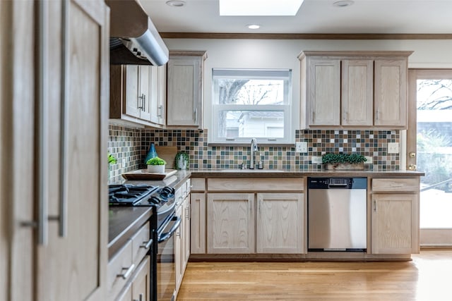 kitchen with dishwasher, sink, exhaust hood, range, and light brown cabinets