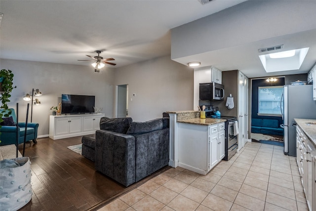 kitchen with white cabinetry, stainless steel appliances, and kitchen peninsula