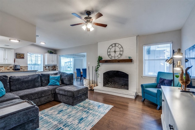 living room with dark hardwood / wood-style flooring, a fireplace, lofted ceiling, and ceiling fan