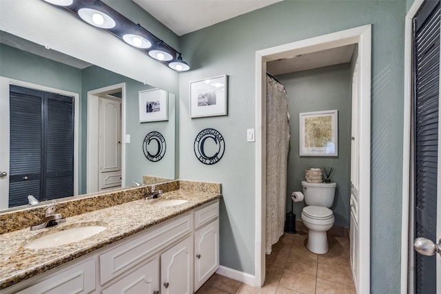 bathroom featuring tile patterned flooring, vanity, and toilet