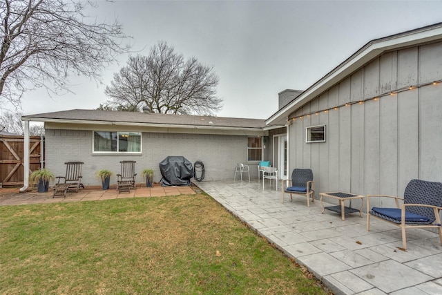 rear view of house with a patio and a yard