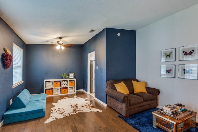 living room featuring wood-type flooring and ceiling fan