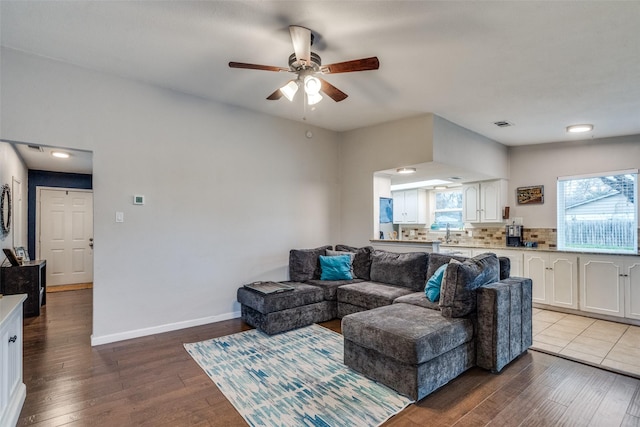 living room featuring sink, hardwood / wood-style floors, and ceiling fan