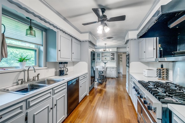 kitchen featuring pendant lighting, sink, dishwasher, extractor fan, and light hardwood / wood-style floors