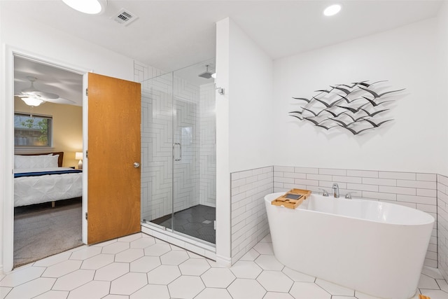 bathroom featuring tile walls, shower with separate bathtub, and ceiling fan