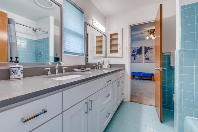 bathroom featuring ceiling fan, vanity, tile patterned flooring, and a tile shower