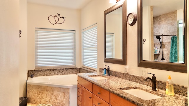 bathroom featuring vanity, plenty of natural light, and a relaxing tiled tub