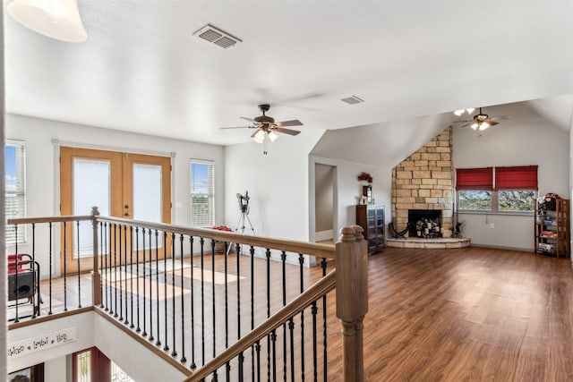 corridor with lofted ceiling, hardwood / wood-style floors, french doors, and a healthy amount of sunlight