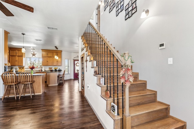 staircase featuring wood-type flooring and ceiling fan