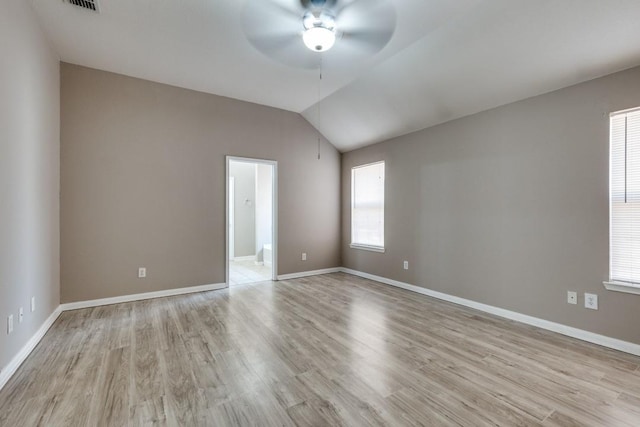 empty room with ceiling fan, vaulted ceiling, and light wood-type flooring