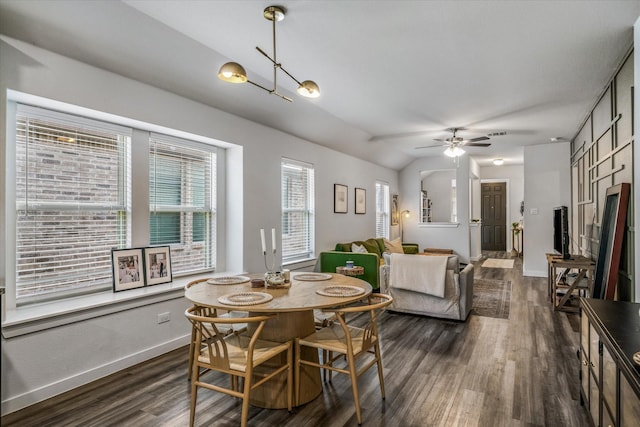 dining area featuring lofted ceiling, dark hardwood / wood-style floors, and ceiling fan with notable chandelier