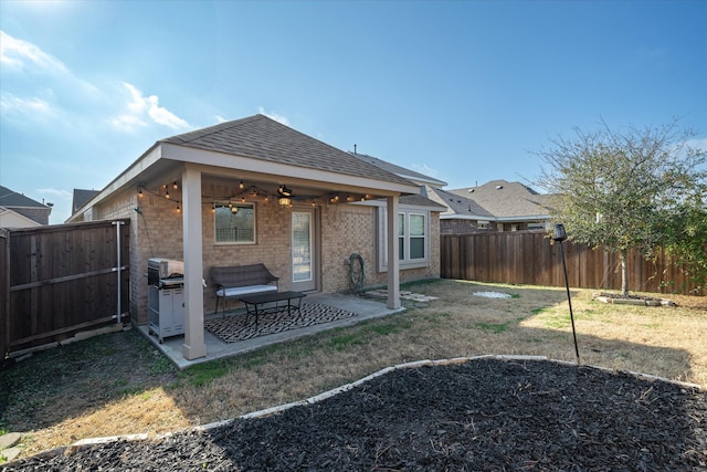 back of property with a patio, a yard, and ceiling fan