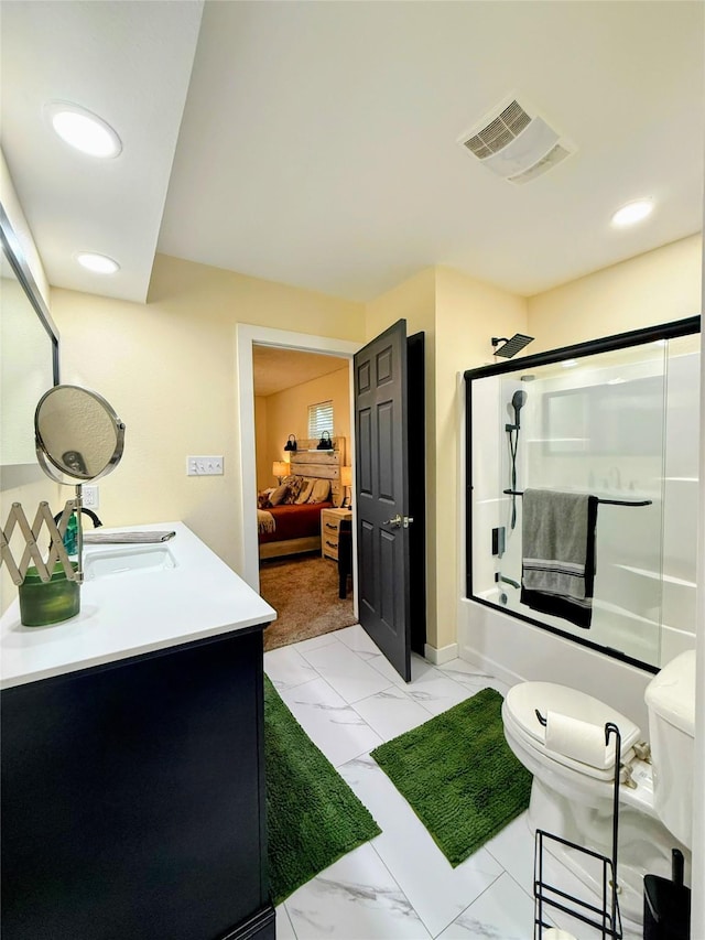 full bathroom featuring vanity, bath / shower combo with glass door, and toilet