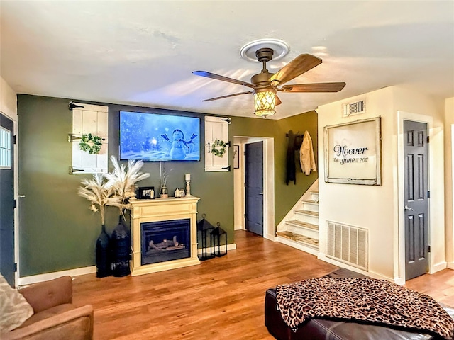 living room featuring ceiling fan and light hardwood / wood-style flooring