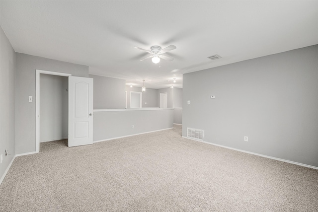 carpeted spare room featuring ceiling fan