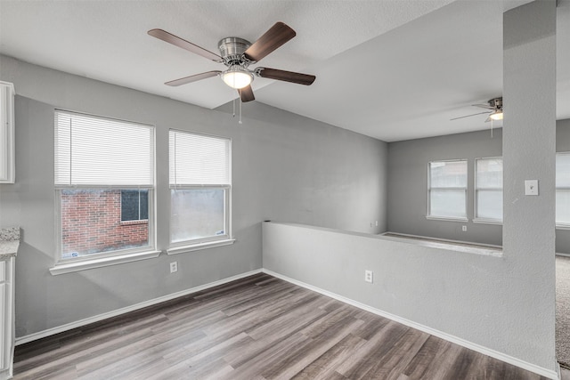 unfurnished room with ceiling fan and wood-type flooring