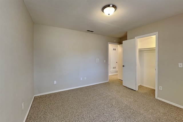 unfurnished bedroom featuring light colored carpet and a closet