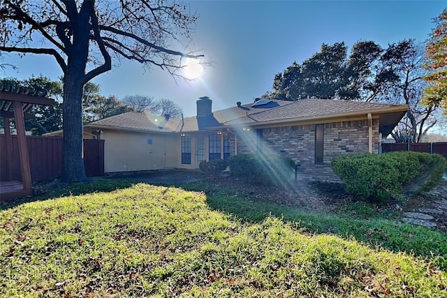 rear view of house featuring a yard