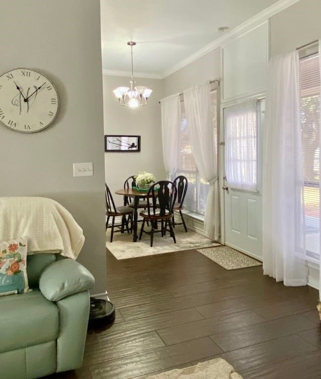 dining space with crown molding, dark wood-type flooring, and an inviting chandelier