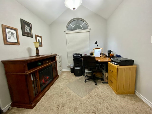 carpeted home office featuring vaulted ceiling