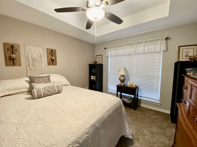 bedroom with ceiling fan, a raised ceiling, and carpet