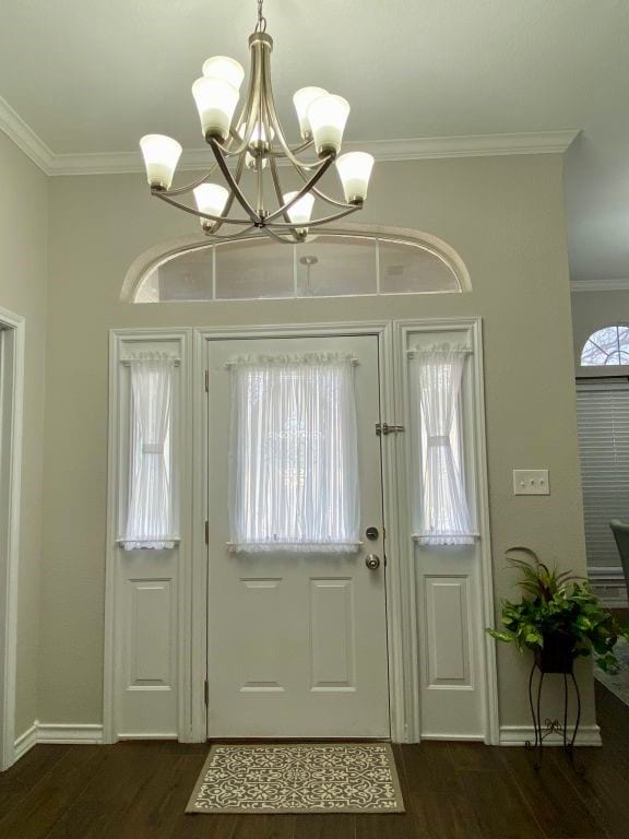 entryway featuring dark hardwood / wood-style flooring, a notable chandelier, and ornamental molding